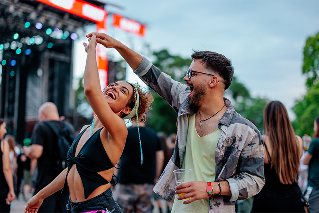 A young couple dancing at a music festival.