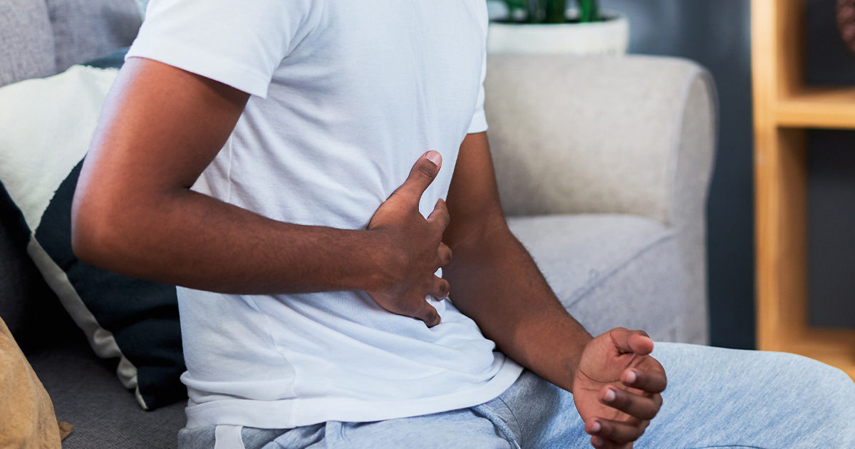 Young Black man grabbing his stomach in pain