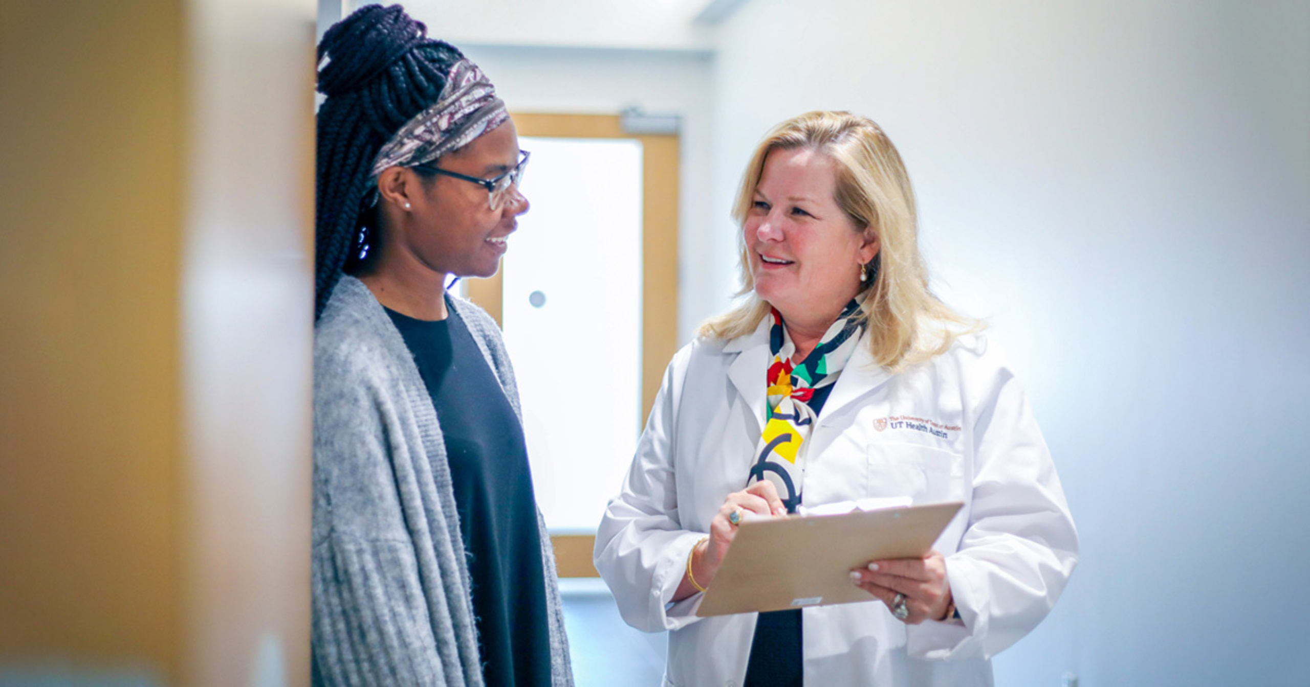 Amy Young, MD, speaking to a patient in a hallway.