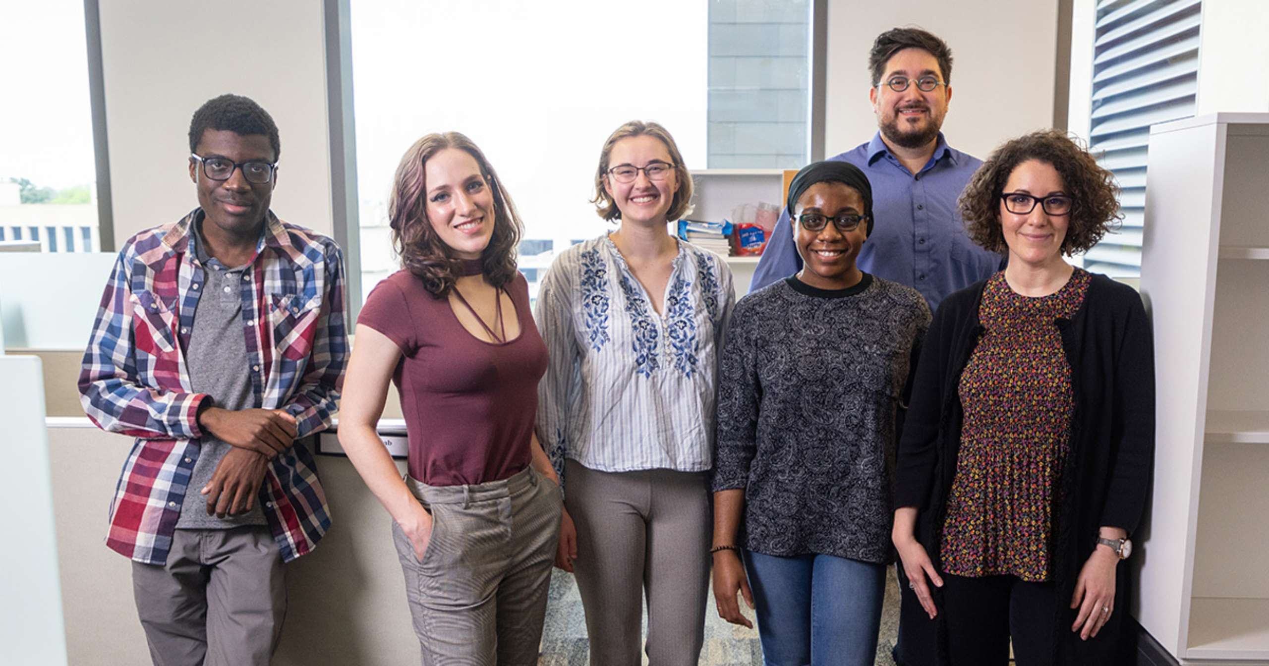 A group photo of Helen Onuorah and lab members standing in their lab. Pictured from left to right: Kenneth Onuorah, Avery Largent, Emily May, Helen Onuorah, Odelin Charron, Dr. Leorah Freeman.