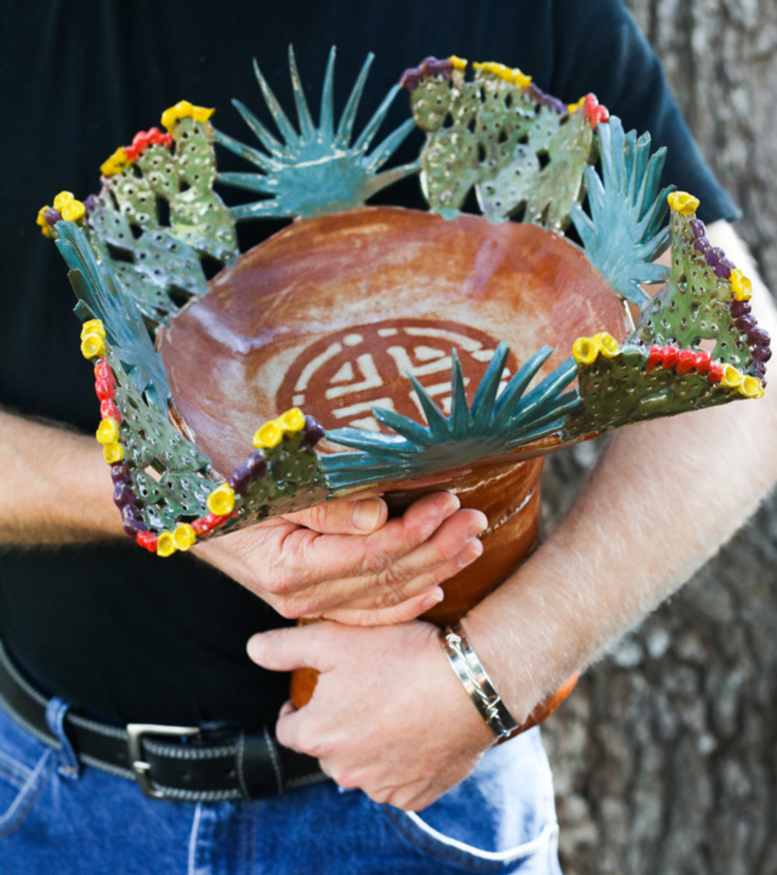 David Warren holds a sculptural art piece in his arms.