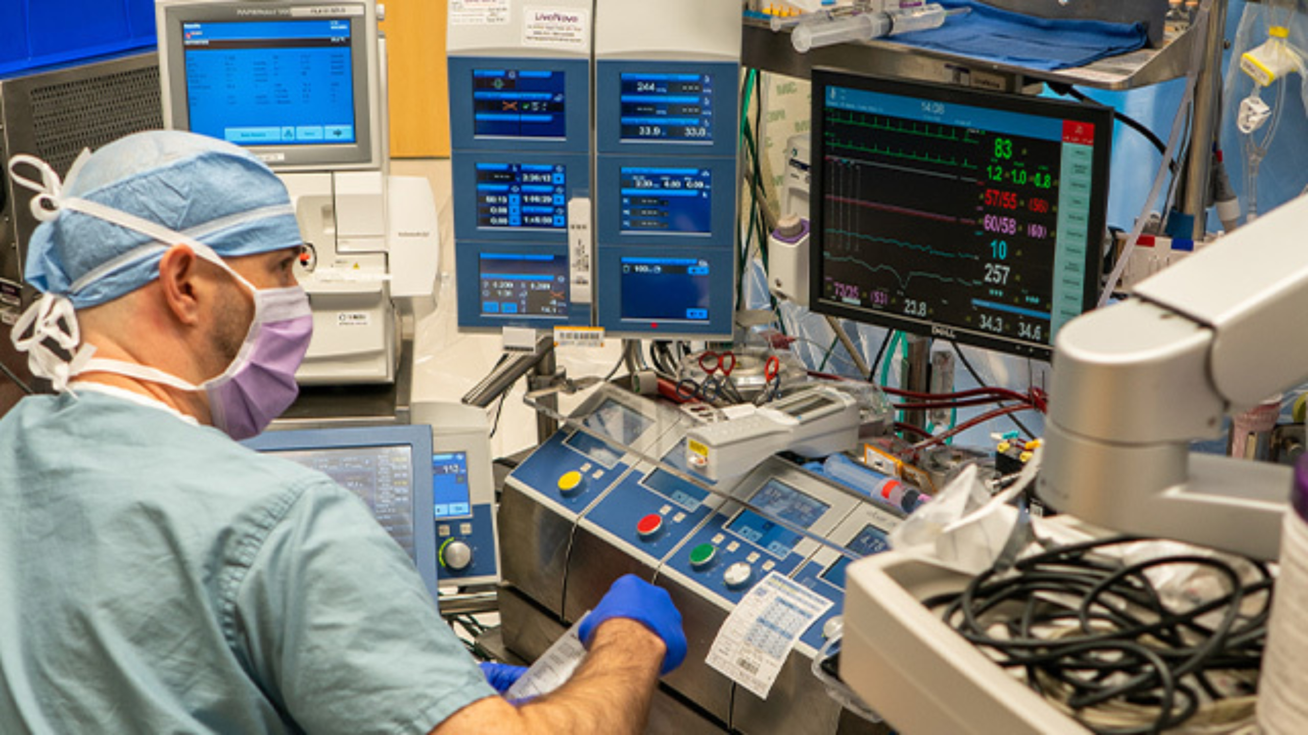 Perfusionist sitting at cardiopulmonary bypass machine.