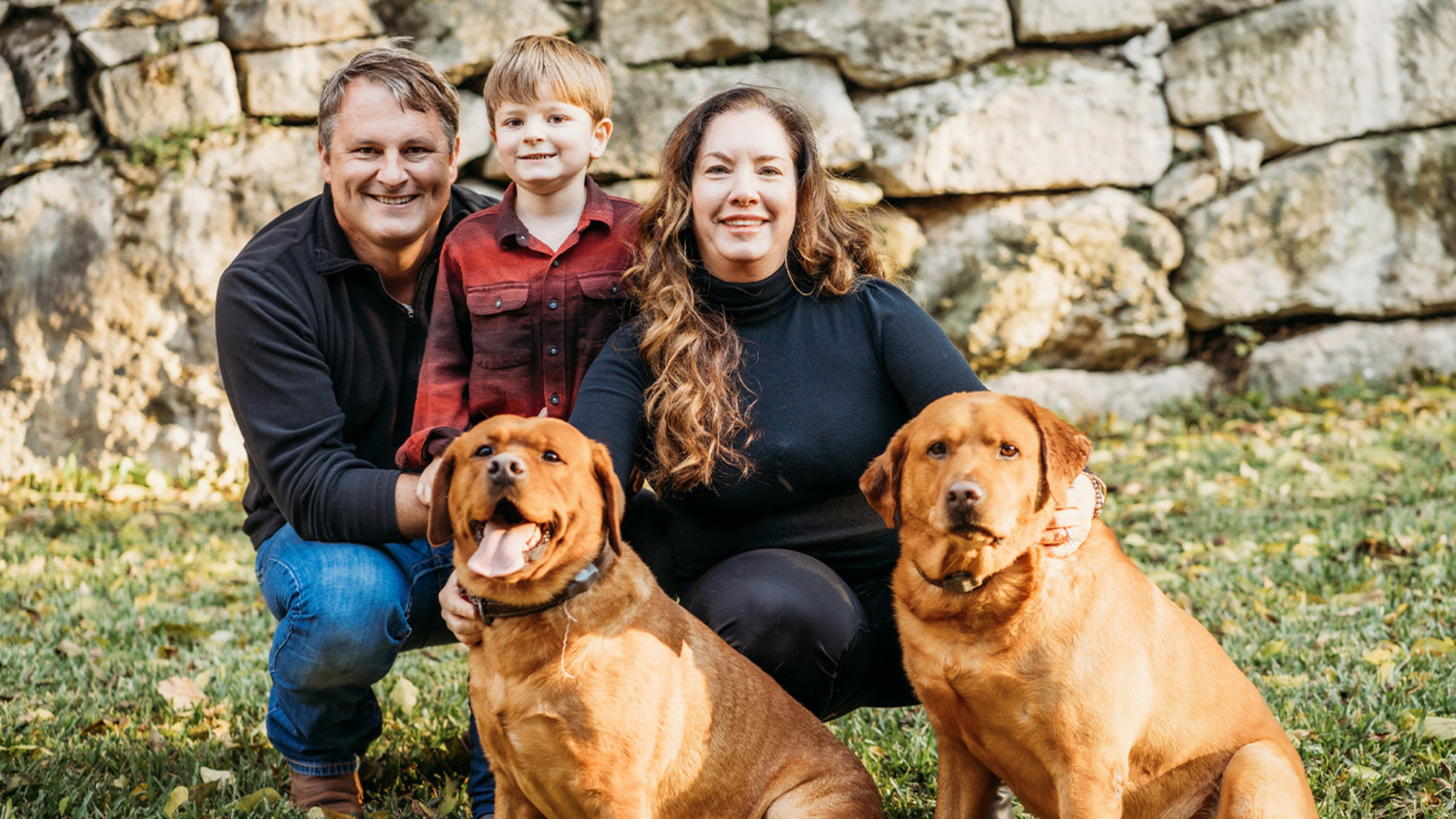 Levi Reeves with his mom and dad in a family photo with their two dogs.