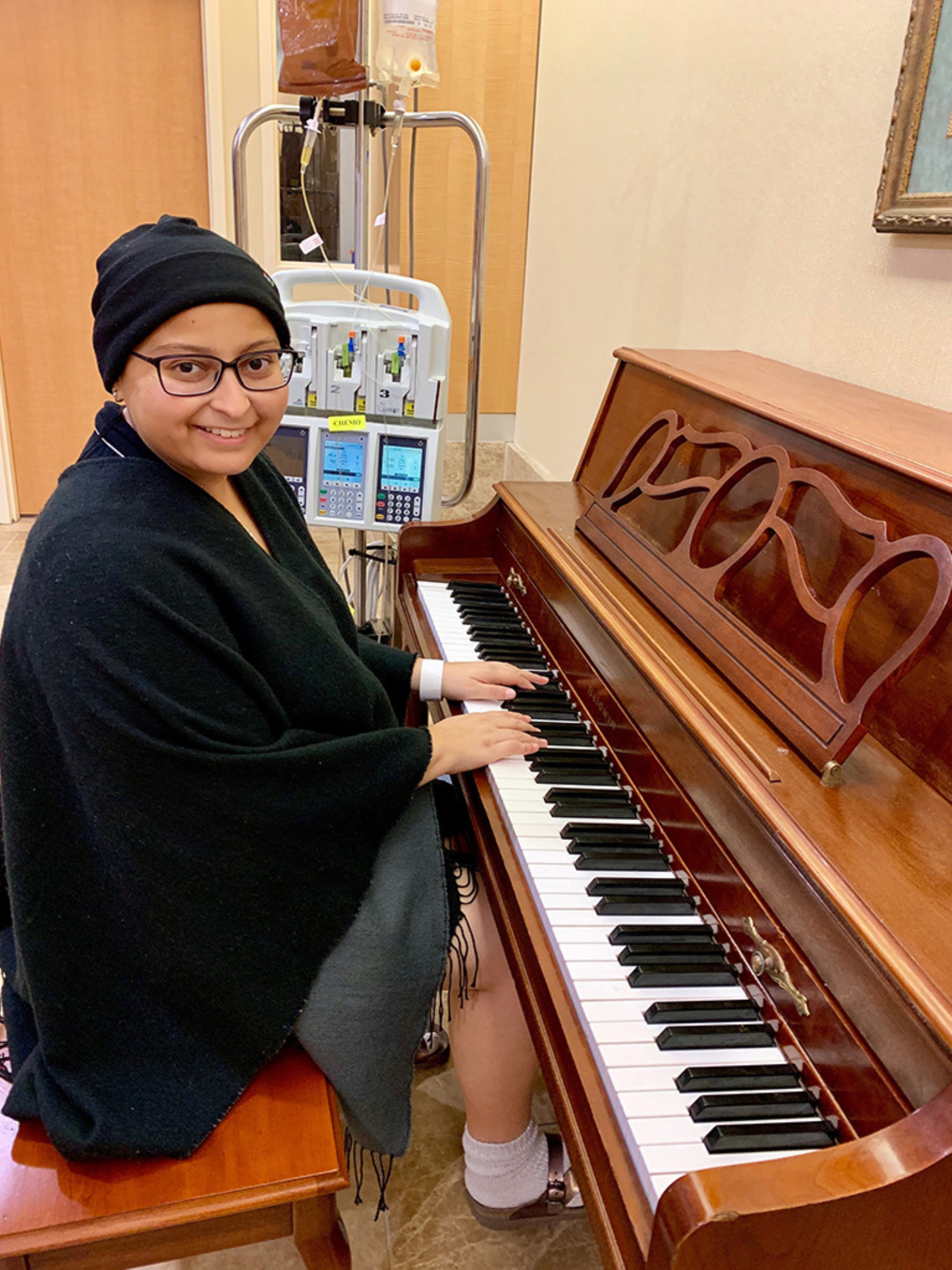 Anmol Desai, a young female cancer survivor, playing the piano at the Ascension Seton Infusion Center, where she received four rounds of chemo.