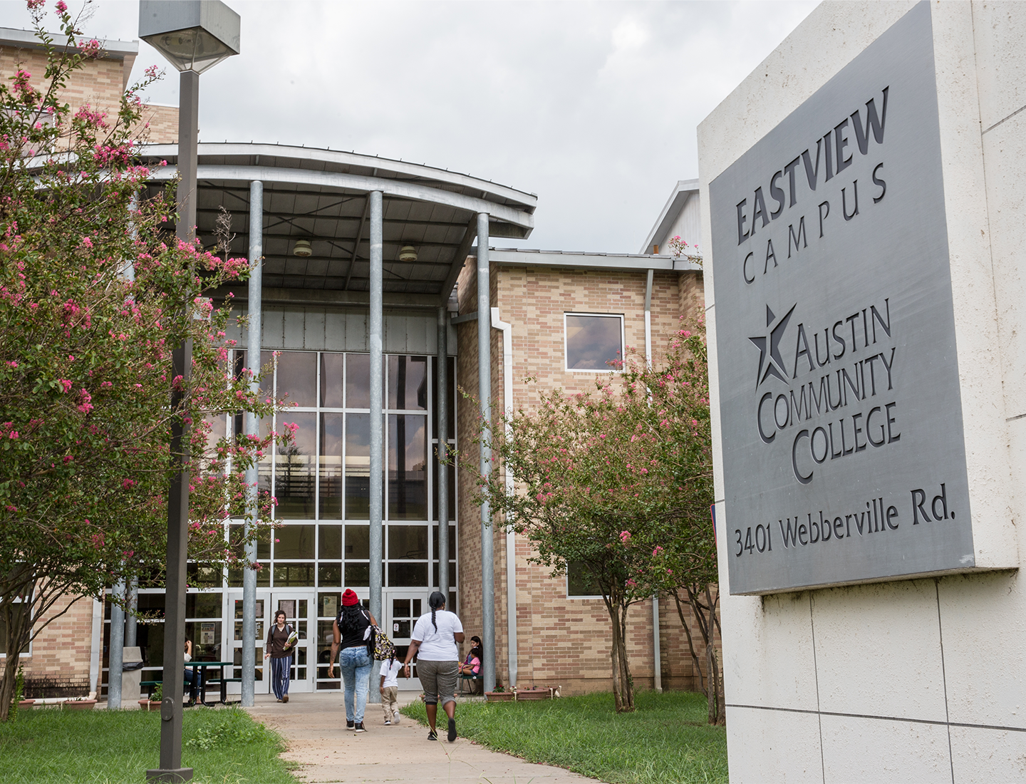 Sign marking the Austin Community College Eastview Campus on Webberville Road in Austin, Texas. A college building is visible in the background.