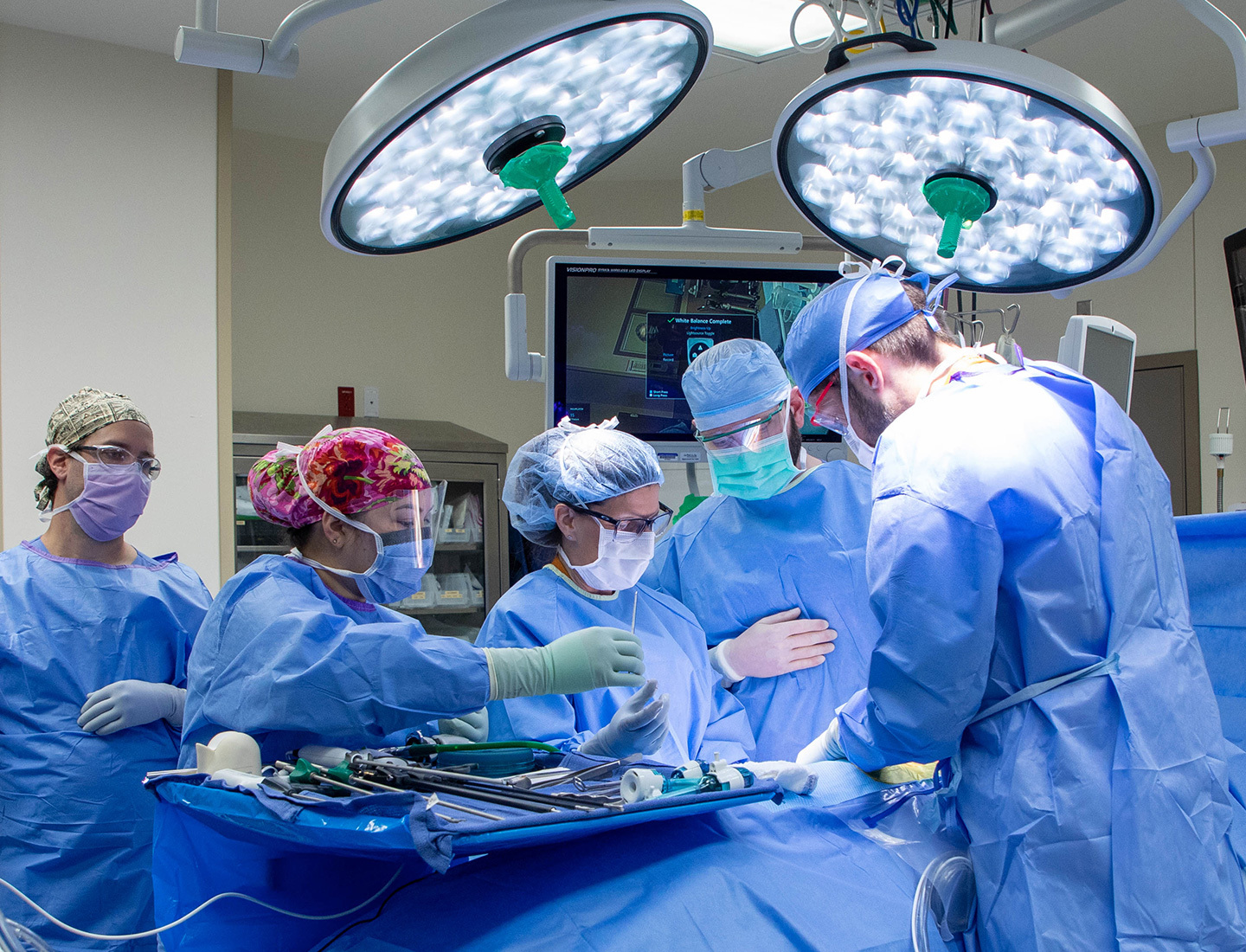 Two transplant surgeons and their team is in the OR gathered around the first kidney donor as they work to remove the organ.