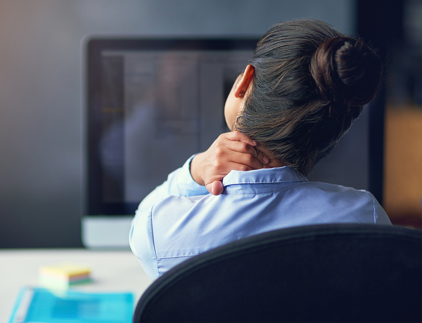 A woman cradling her head and neck in her hand.