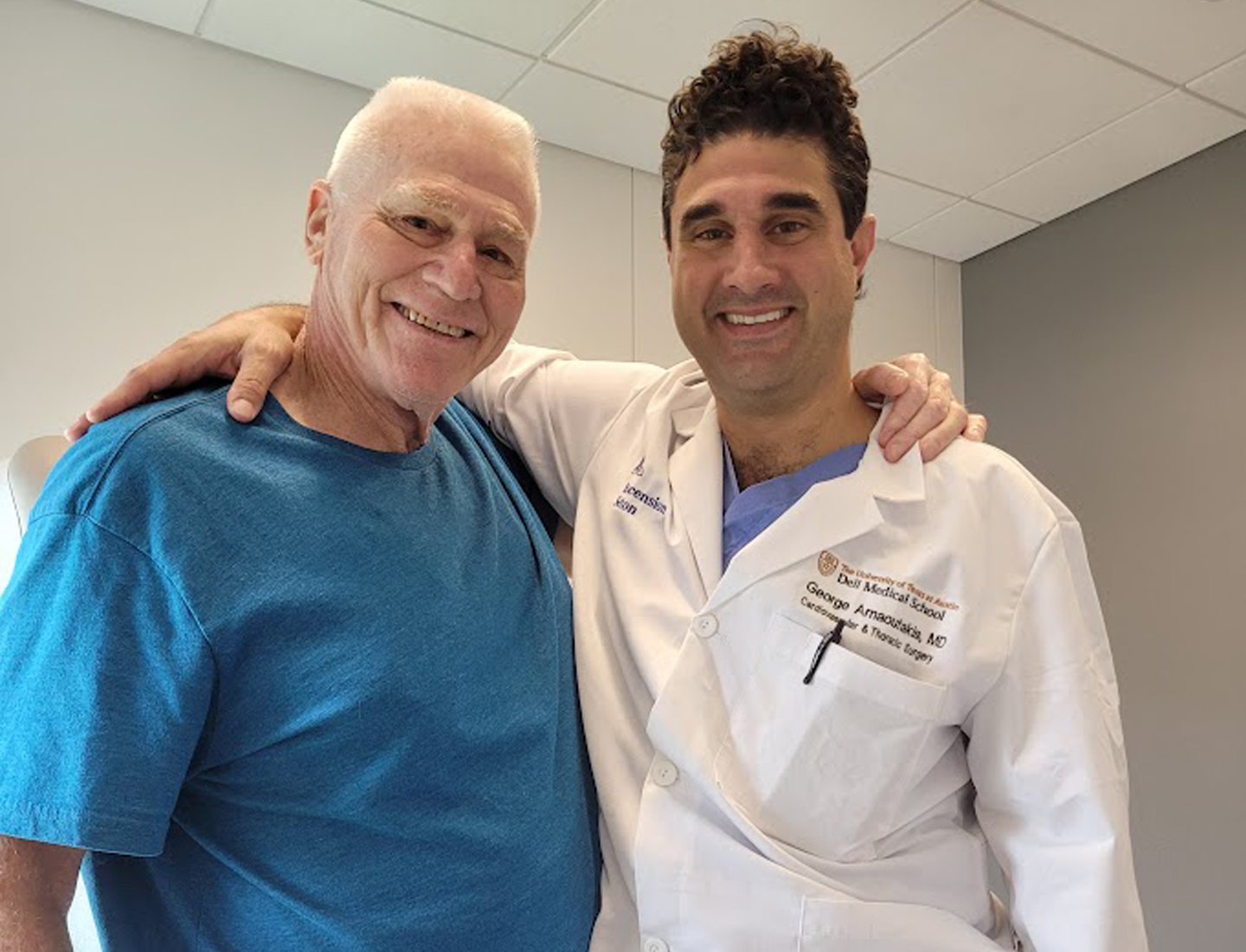 Coach Neil Gruber smiling with former student, cardiothoracic surgeon George Arnaoutakis, MD.