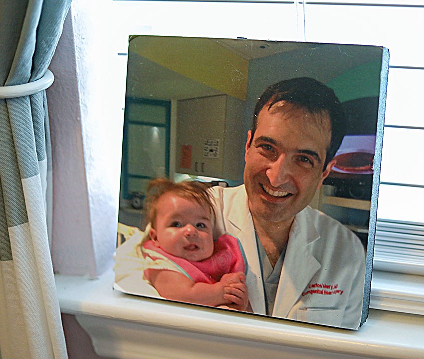 Dr. Carlos Mery holds infant Addy so she can see herself in a mirror.