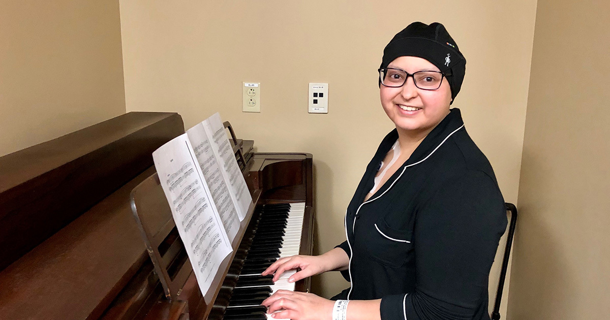 Anmol Desai, a young female cancer survivor, playing the piano at the Ascension Seton Infusion Center, where she received four rounds of chemo.