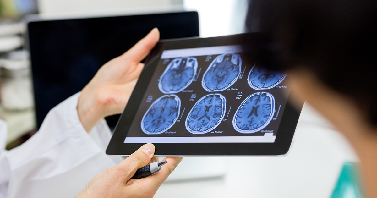 A provider shares an MRI image on a tablet with another provider.