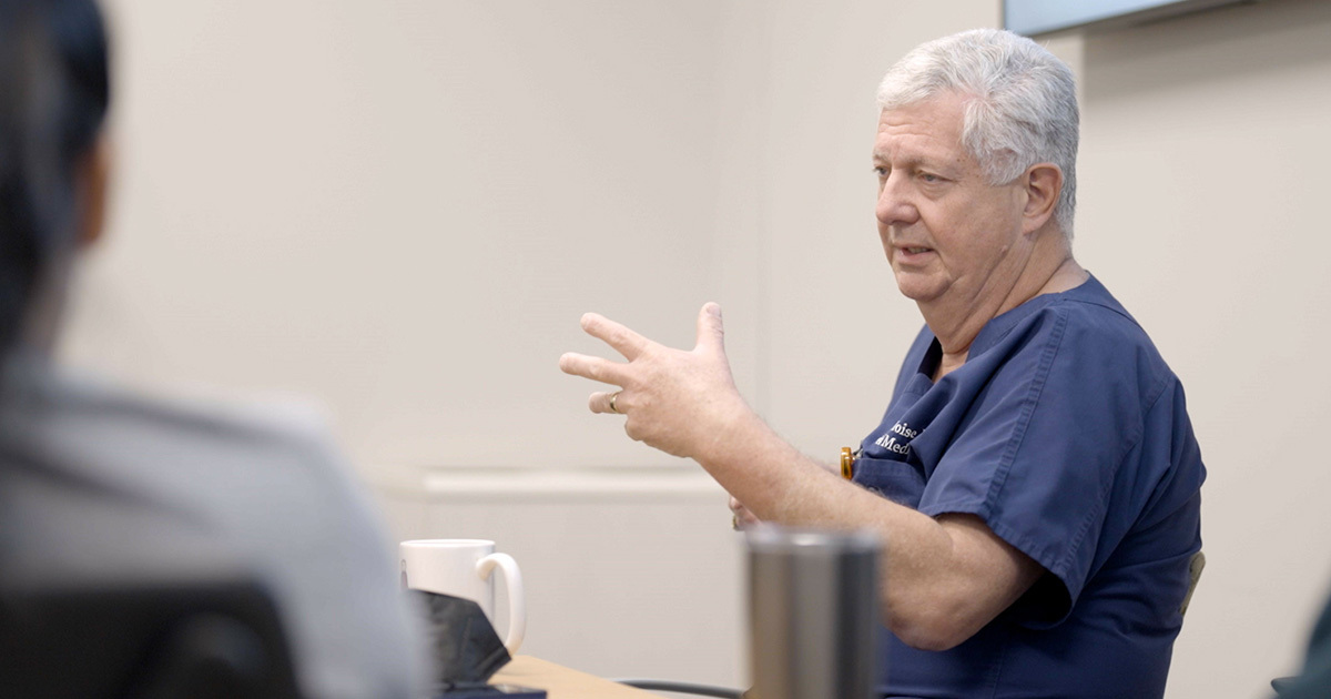 Kenneth J. Moise, Jr., MD, addressing a group seated around a conference table.