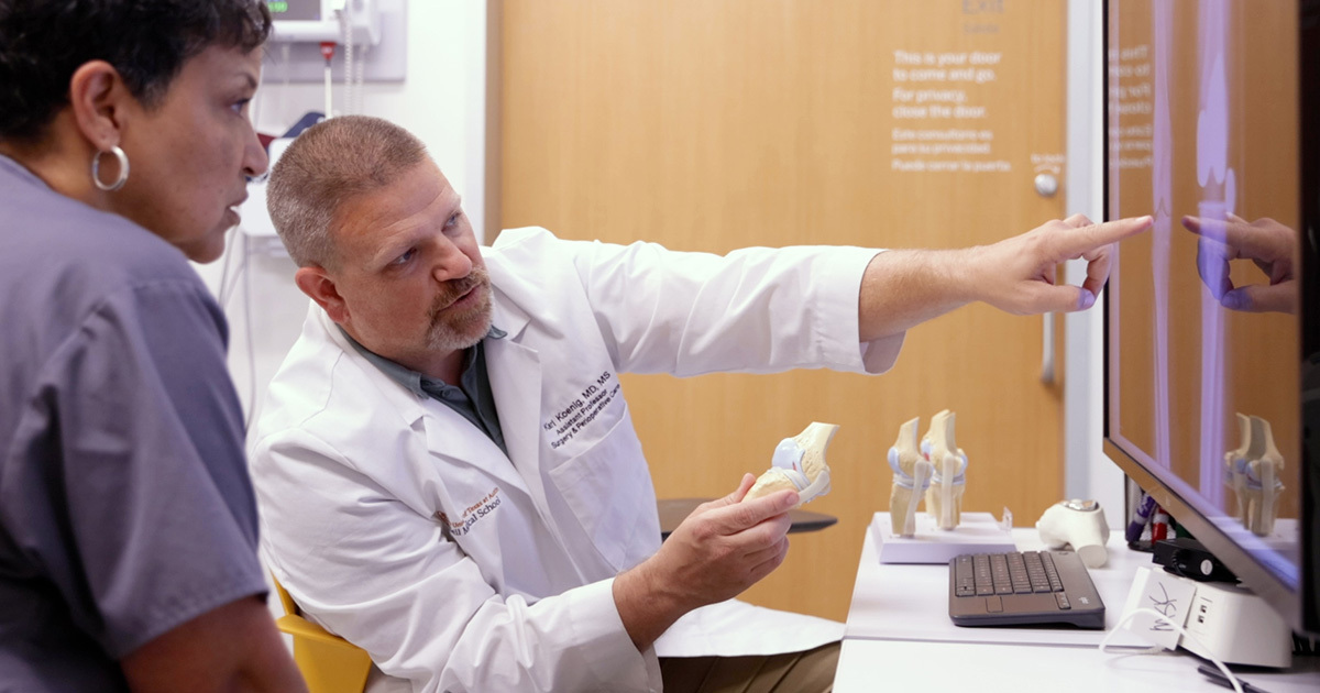 Karl Koenig, MD, pointing to an x-ray scan of a bone.