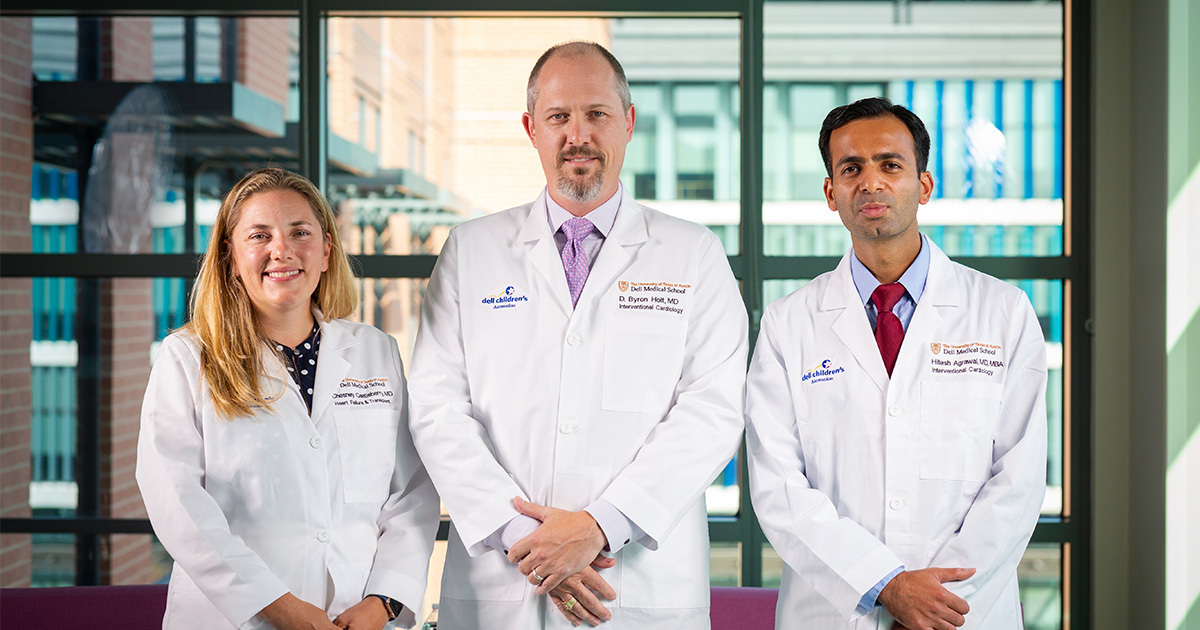 Drs. Chesney Castleberry, Byron Holt, and Hitesh Agrawal stand in a conference room after joining UT Health Austin's medical group.