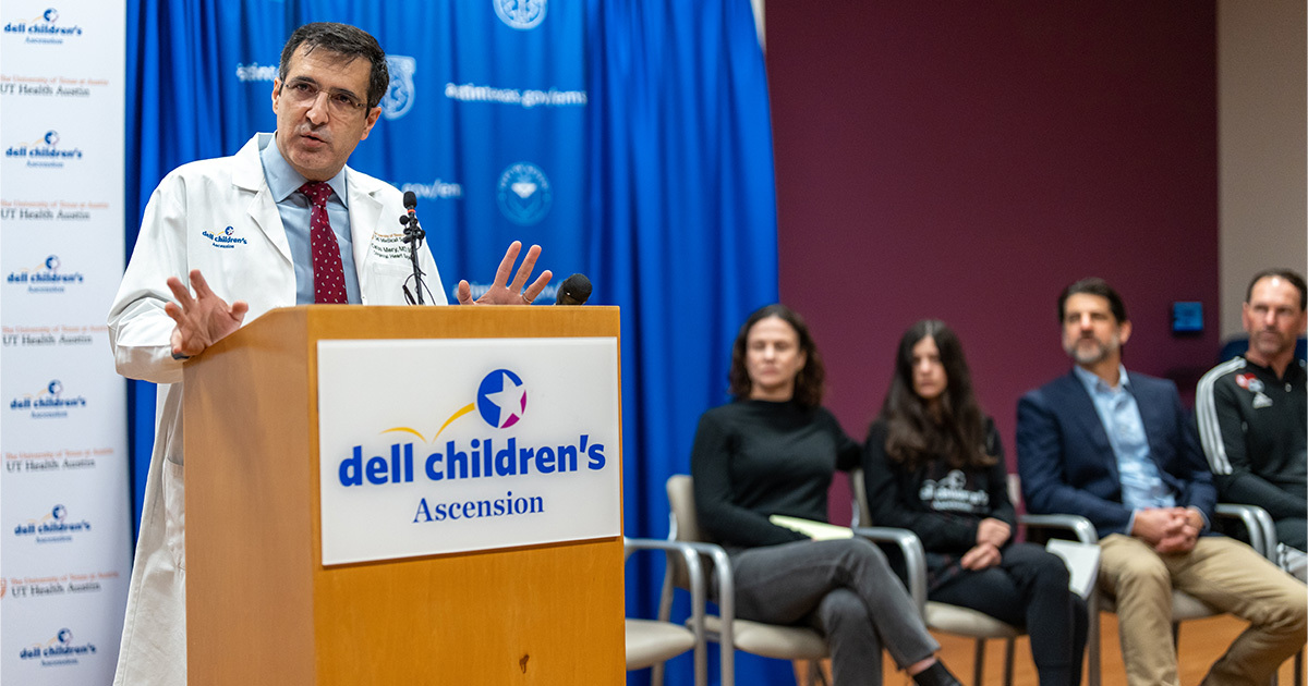 Dr. Carlos M. Mery addressing a press conference as the Barrett family looks on.