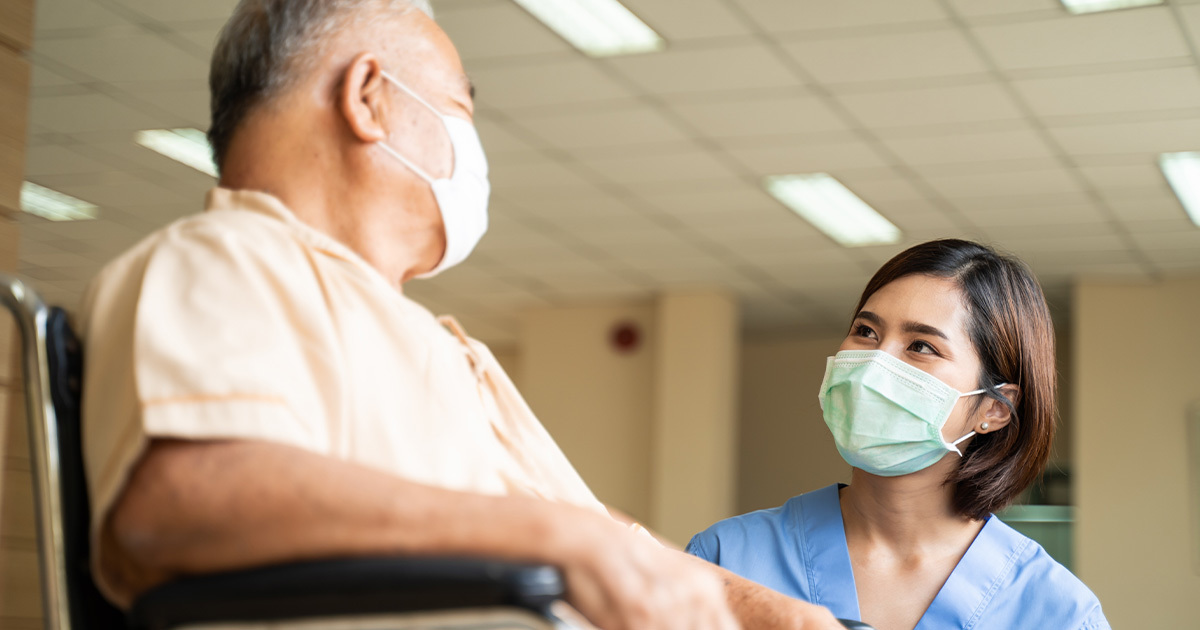 Medical provider speaking with patient in wheelchair