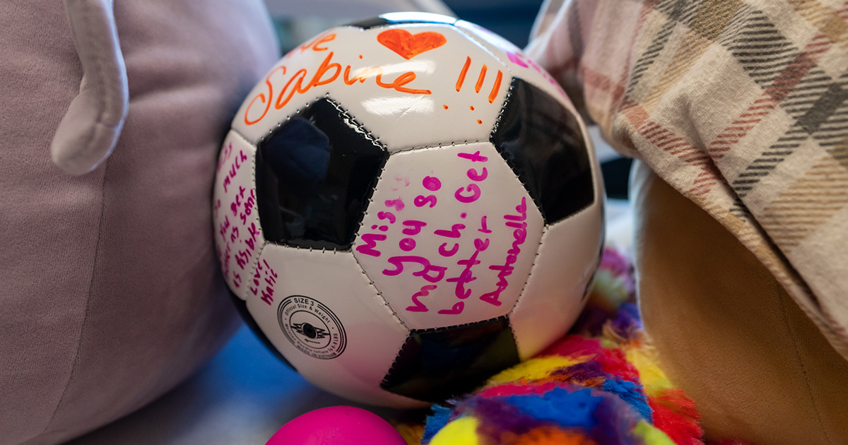 Soccer ball signed with colored markers with encouraging messages for Sabine Barrett.