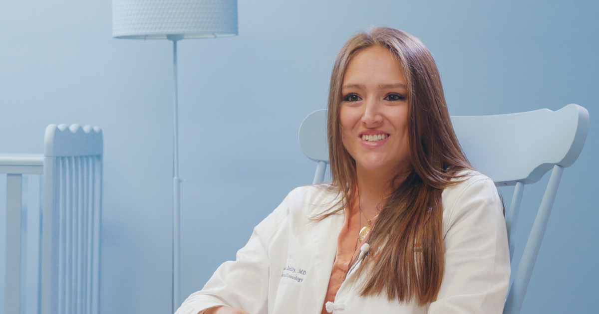 Justine Reilly, MD, an ob-gyn for Women's Health, is seated in a rocking chair with in a blue baby's room answering questions about the 2nd trimester of pregnancy.