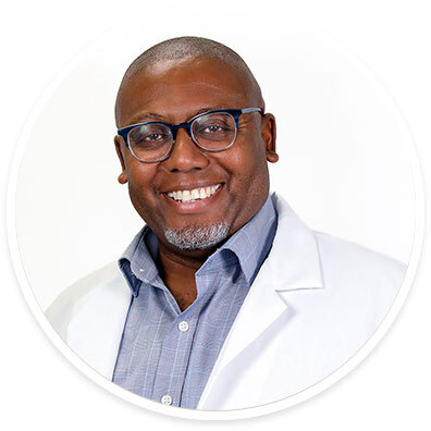 Pediatric epileptologist Dave Clarke, MD, wearing a white coat and smiling in front of a white backdrop.