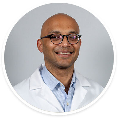 Gastroenterologist Deepak Agrawal, MD, MPH, wearing a white coat and smiling in front of a white background.