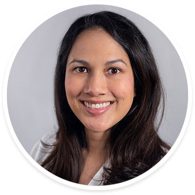 Ophthalmologist Eileen Bowden, MD, wearing a white coat and smiling in front of a white backdrop.