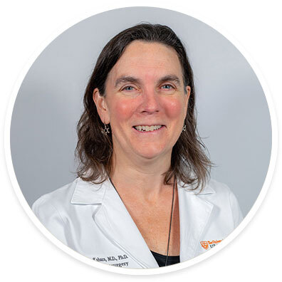 Pediatric neurosurgeon Elizabeth C. Tyler-Kabara, MD, PhD, smiling and wearing a white coat in front of a white backdrop.