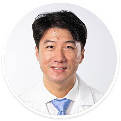 Ophthalmologist Gene Kim, MD, wearing a white coat and smiling in front of a white backdrop.