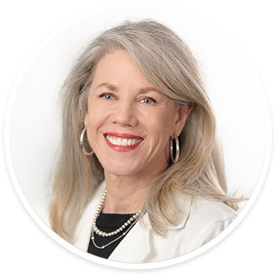 Pediatric neuro-ophthalmologist Jane C. Edmond, MD, wearing a white coat and smiling in front of a white backdrop.