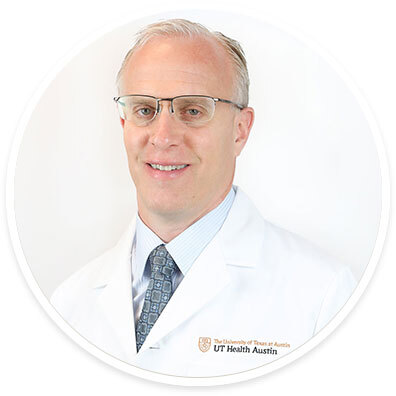 Orthopedic surgeon Kevin Bozic, MD, MBA, FAOA, FAAOS, wearing a white coat and smiling in front of a white backdrop.