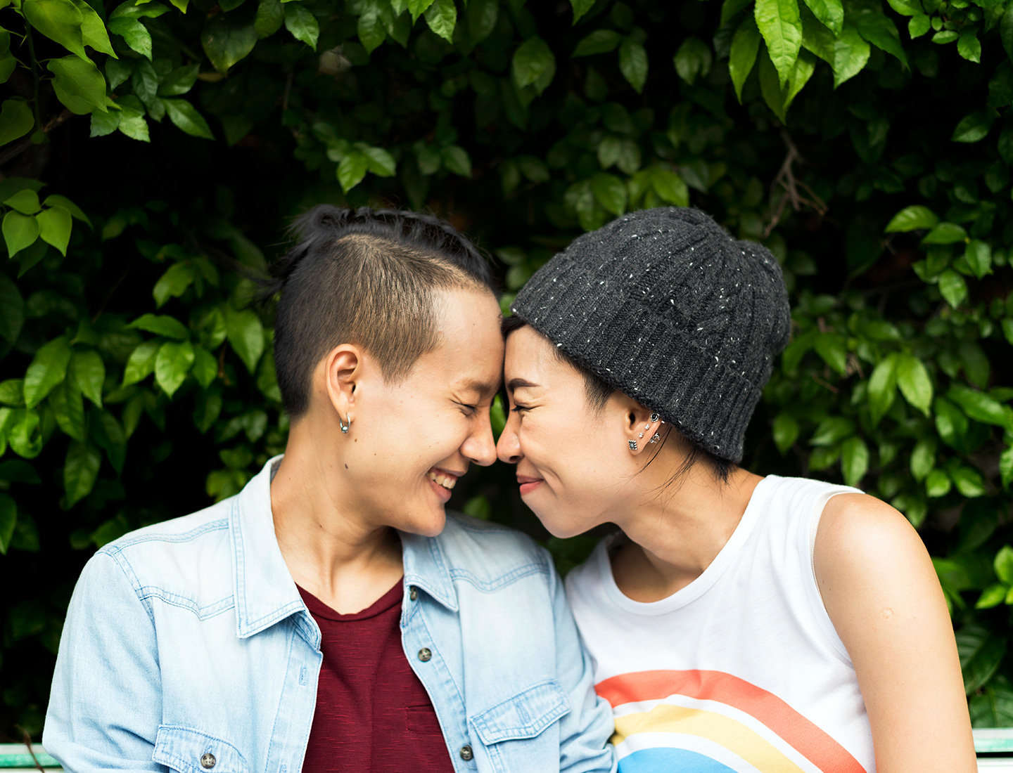 Two young women embrace and touch noses in an expression of affection and love.