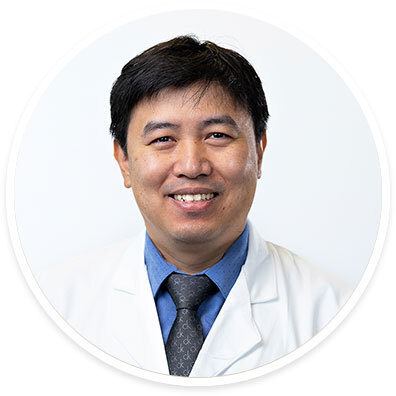 Neuro-ophthalmologist Moe “Harry” Hein Aung, MD, PhD, wearing a white coat and smiling in front of a white backdrop.