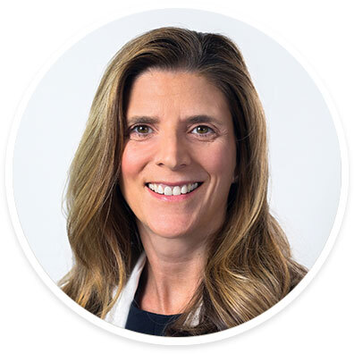 Abdominal transplant surgeon Nicole Turgeon, MD, FACS, wearing a white coat and smiling in front of a white backdrop.