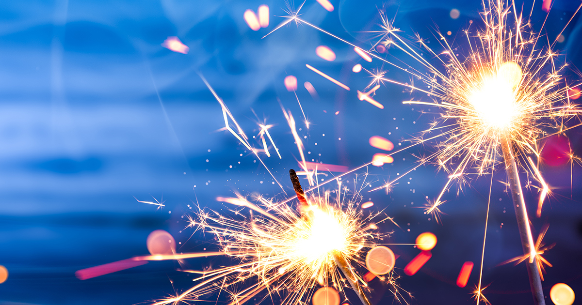 Close-up photo of lit sparklers illuminating the night.