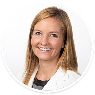 Pediatric neurologist Sara Pavitt, MD, wearing a white coat and smiling in front of a white backdrop.