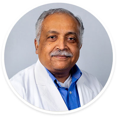 Pediatric neurologist Vettaikorumakankav Vedanarayanan, MD, FRCPC, wearing a white coat and smiling in front of a white backdrop.