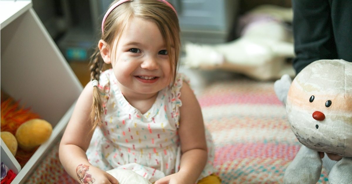 Addie, a child born with heterotaxy syndrome, smiles in her playroom after recovering from her third surgery at Dell Children's in Austin.