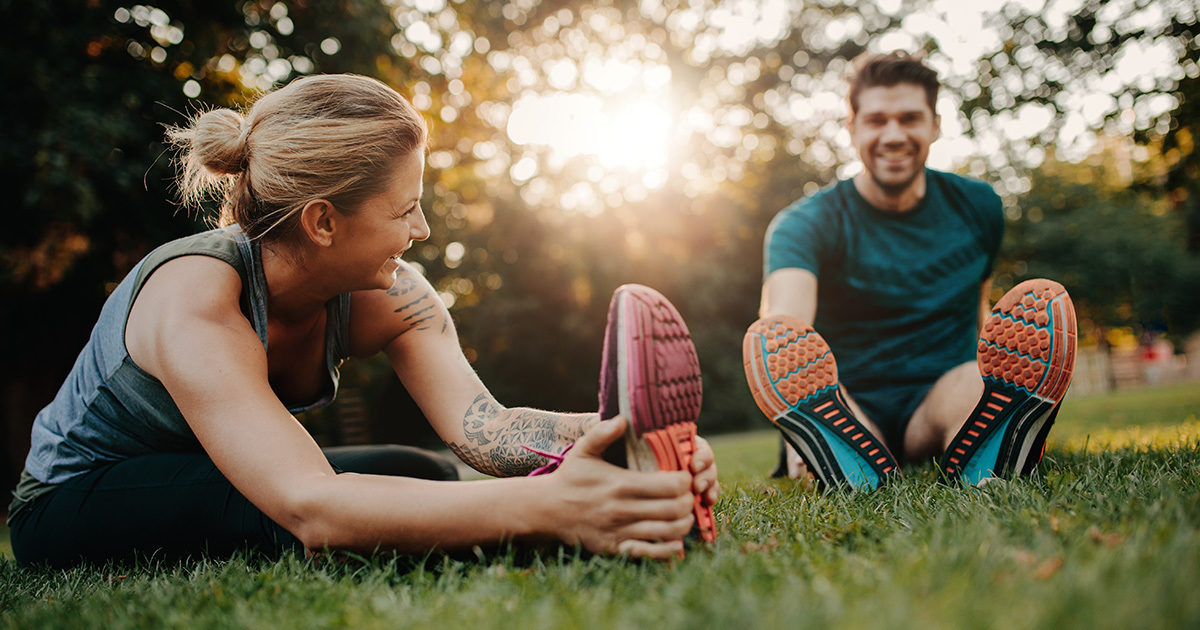 Young woman and man stretching before a run