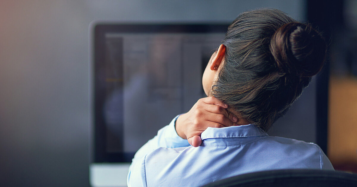 A woman cradling her head and neck in her hand.