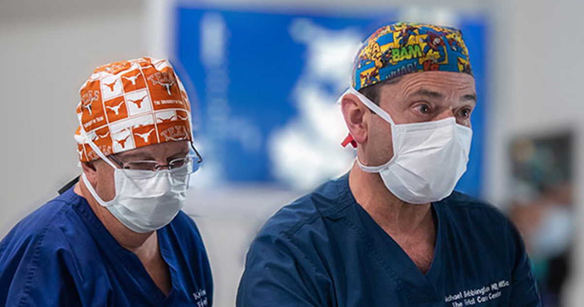 Kenneth Moise, MD and Richard Bebbington, MD in scrub caps and masks prepare for twin twin laser in utero surgery.