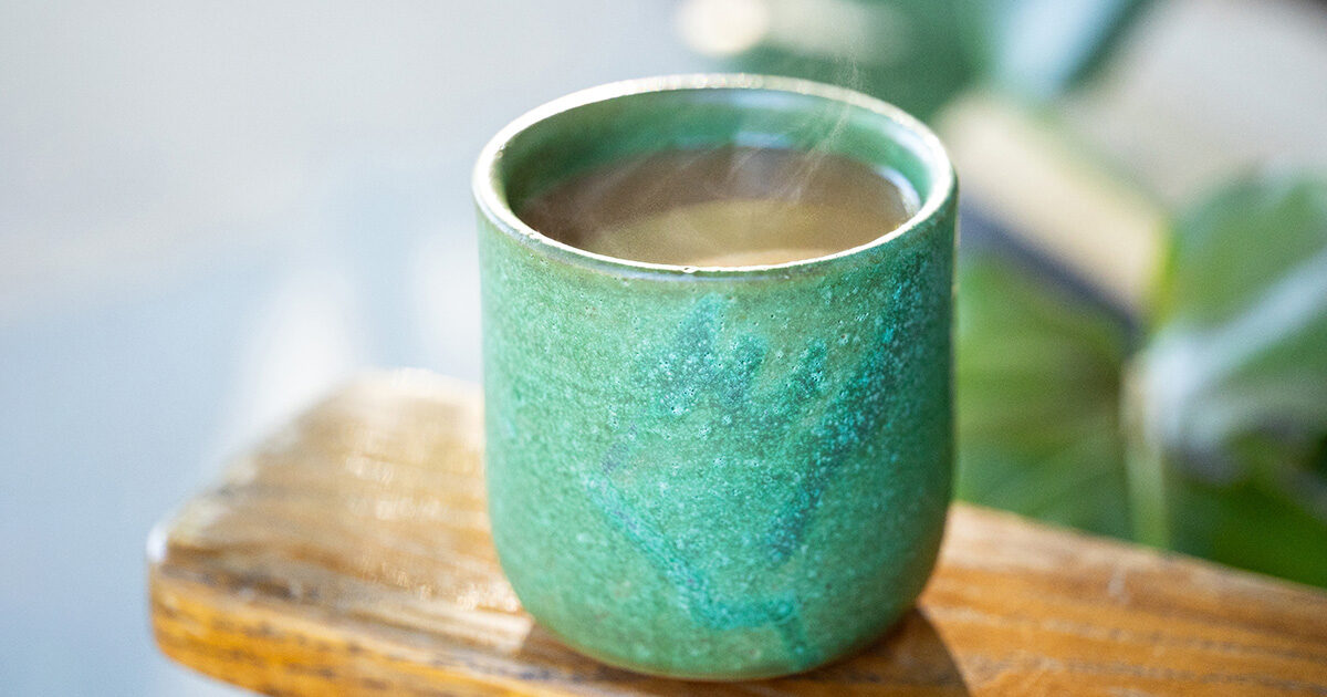 Warm coffee in a green ceramic mug.