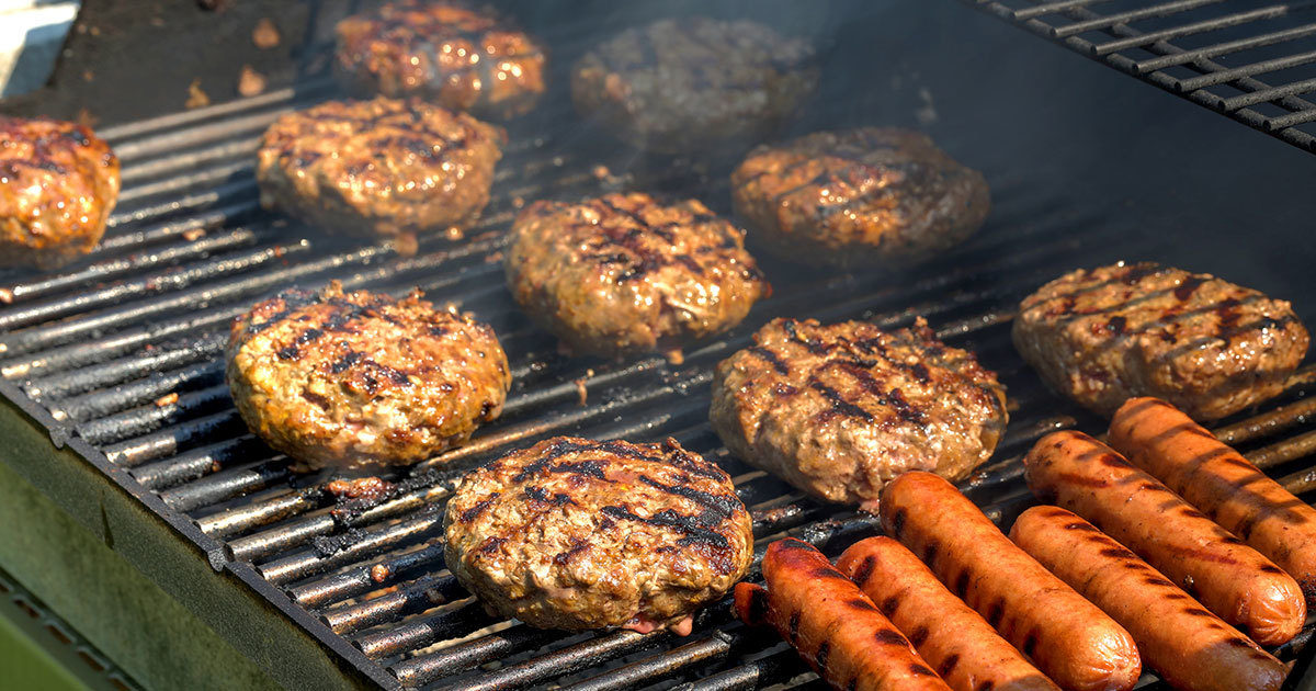 Hamburgers and hot dogs being cooked on a grill