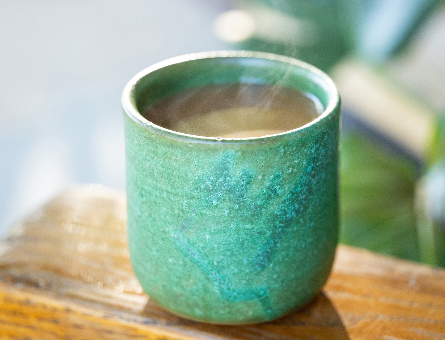 Warm coffee in a green ceramic mug.
