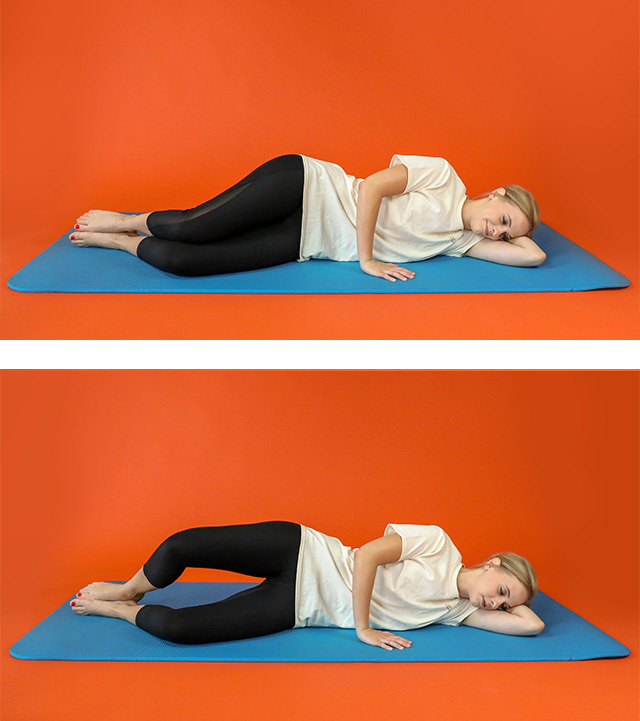 A woman performs a clamshell exercise by lying on her side with her knees bent and stacked together and then lifting one knee while her feet remain touching.