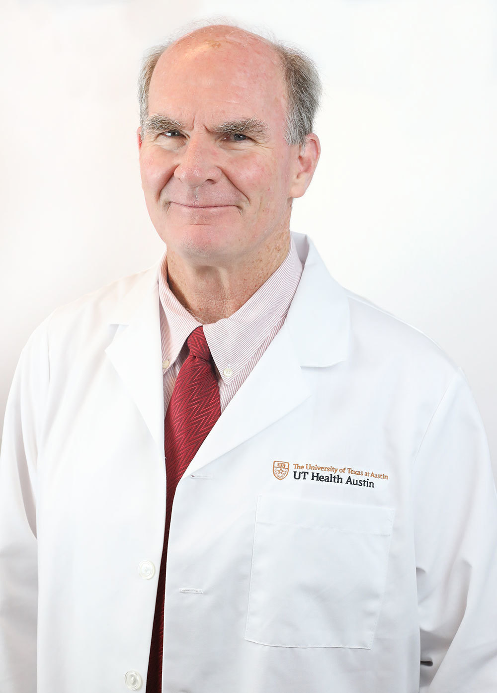 Minimally invasive gynecologic surgeon Michael Breen, MD, wearing a white coat and smiling in front of a white backdrop.