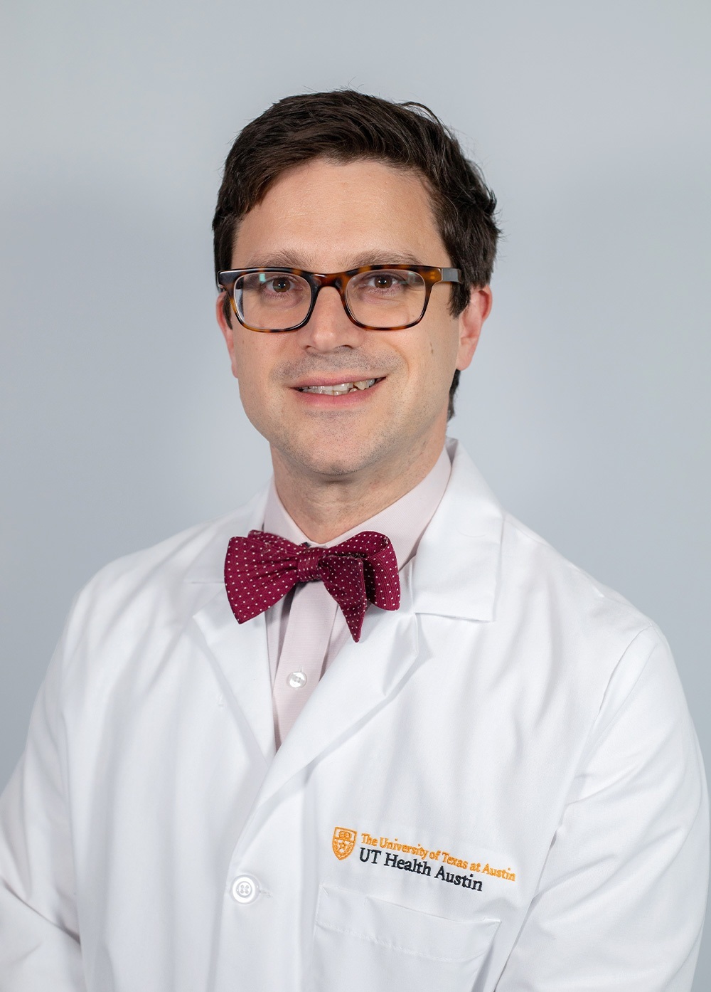 Dr. Alex B. Haynes wearing a white coat and smiling in front of a white backdrop.