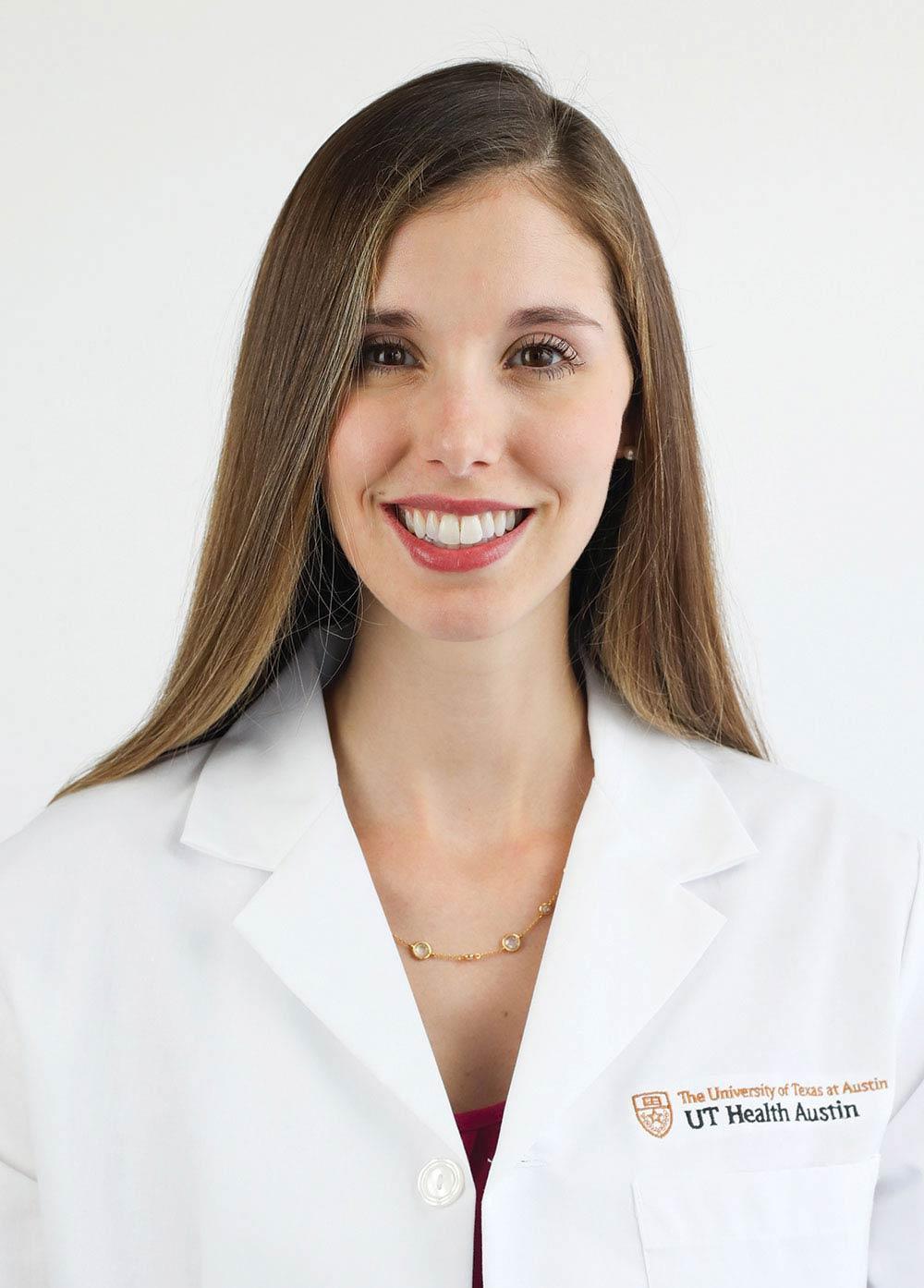 Nurse practitioner Amy Papermaster, PhD, NP-C, RN, wearing a white coat and smiling in front of a white backdrop.