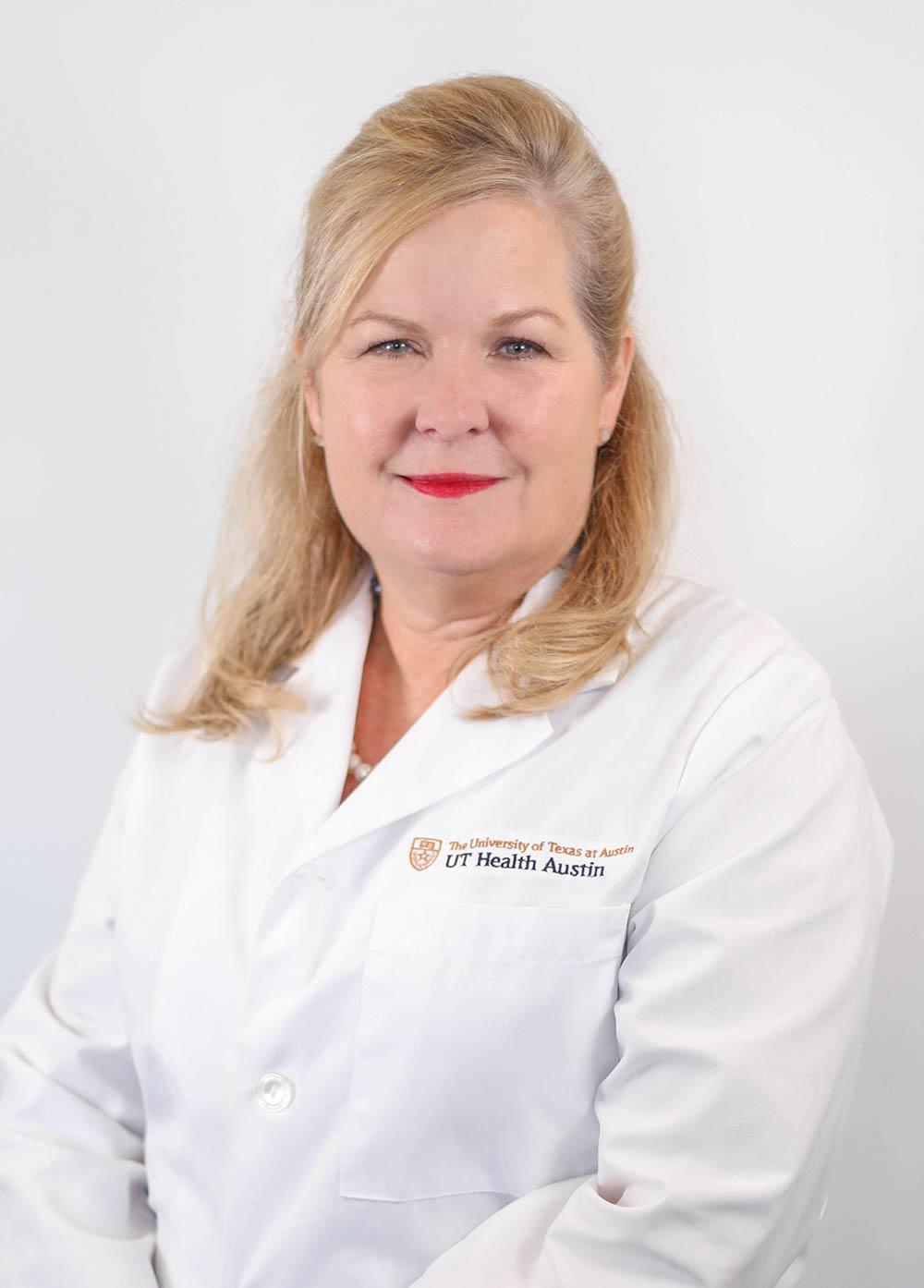 Obstetrician-gynecologist Amy Young, MD, wearing a white coat and smiling in front of a white backdrop.