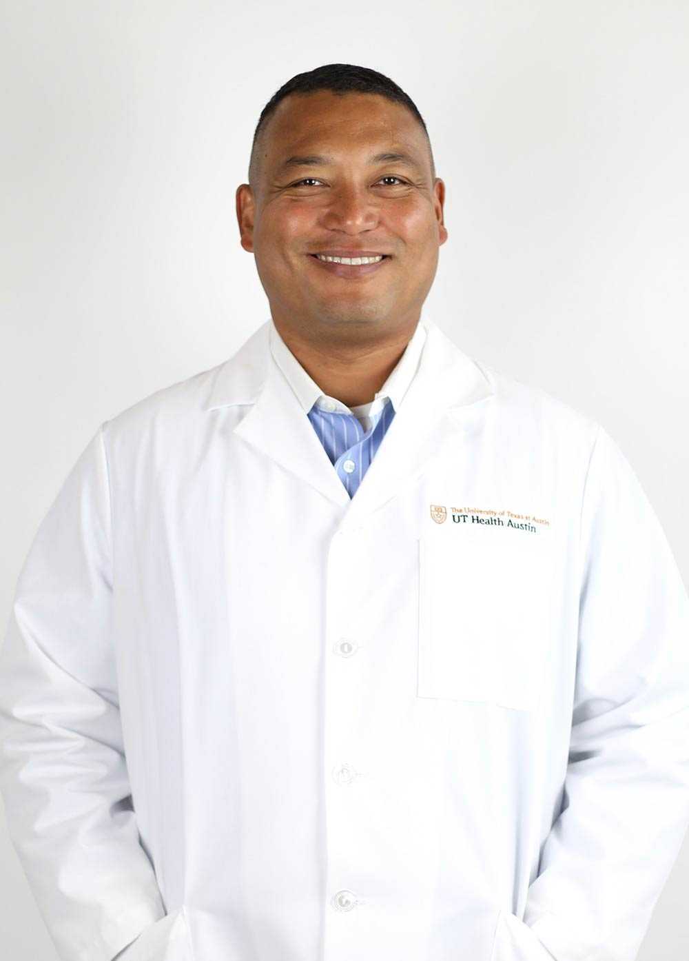 Orthopedic surgeon Anthony "AJ" Johnson MD, FAOA, FACS, FAAOS, wearing a white coat and smiling in front of a white backdrop.