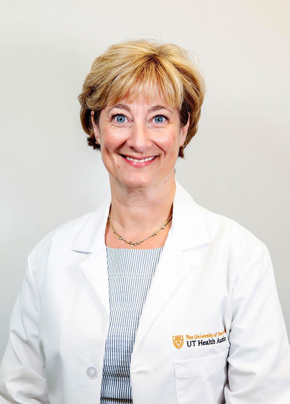 Maternal-fetal medicine specialist Celeste Sheppard MD, FACOG, wearing a white coat and smiling in front of a white backdrop.