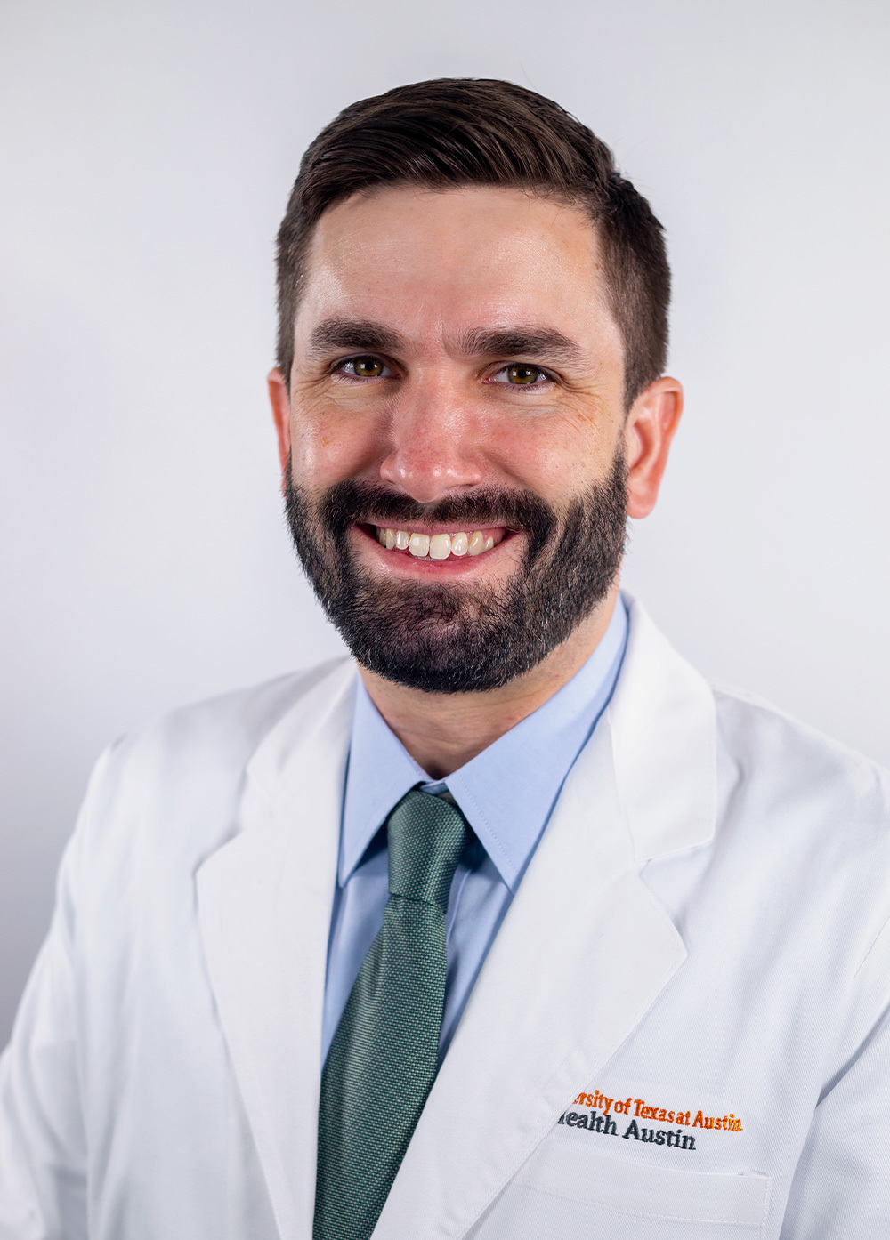 Pediatric neurologist Daniel Freedman, DO, wearing a white coat and smiling in front of a white backdrop.